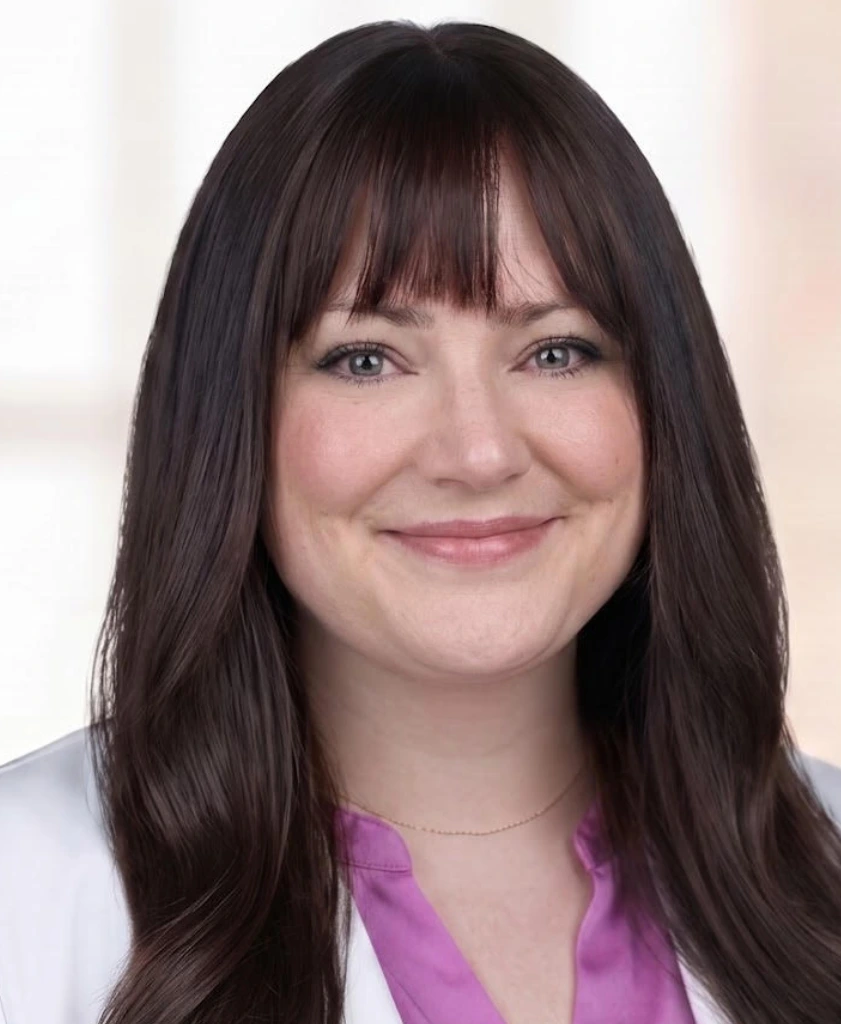 The image is a headshot of Samantha Chartash, PMHNP-BC from Inner Compass Psychiatry & Wellness. Samantha has brown hair with bangs, and is wearing a pink shirt with a white labcoat.